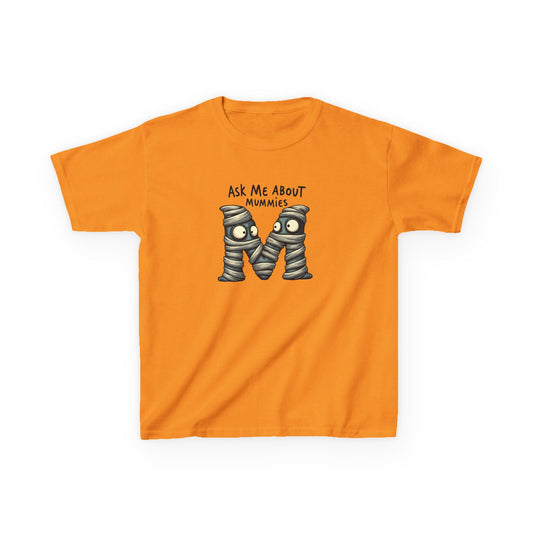 Kids history-themed shirt with “Ask Me About Mummies” design featuring cartoon mummy lettering on a Gildan 5000B Heavy Cotton Tee. Tennessee Orange