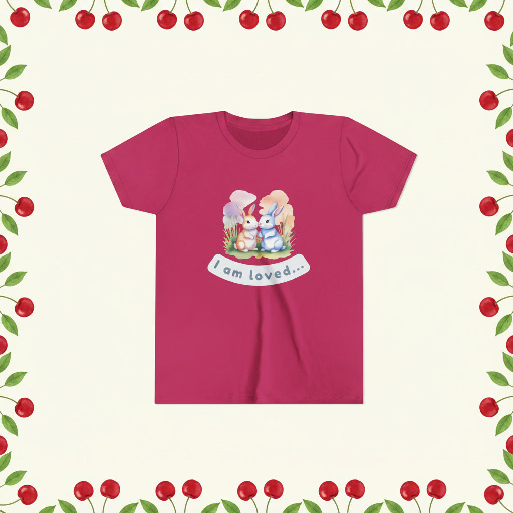 Pink t-shirt with cartoon bunnies and 'I am loved' text on a white background