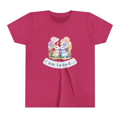 Pink t-shirt with cartoon bunnies and 'I am loved' text on a white background