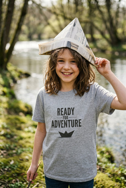 Kids grey T‑shirt with bold black “Ready for Adventure” text and a small paper boat graphic. AI-generated image of achild