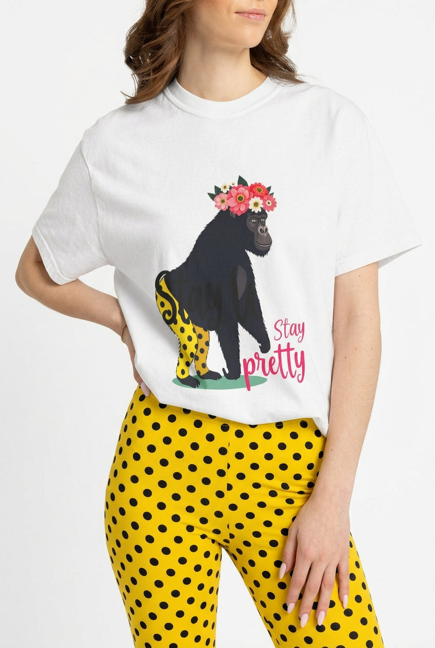 AI model wears tee “Girl‑Girl™ gorilla wearing a flower crown and patterned shorts on a white unisex tee with the phrase ‘Stay Pretty.’”  Yellow pants with black dots were AI-generated.
