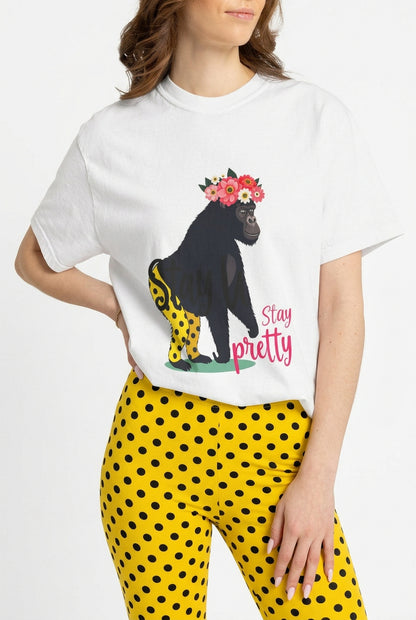 AI model wears tee “Girl‑Girl™ gorilla wearing a flower crown and patterned shorts on a white unisex tee with the phrase ‘Stay Pretty.’”  Yellow pants with black dots were AI-generated.