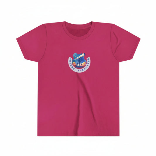 A berry pink short-sleeve crewneck t-shirt featuring a colorful 'Future Stargazer' telescope graphic printed on the center chest, displayed against a background with model planets and moon hanging from the ceiling. Malika Bourne Legacy design