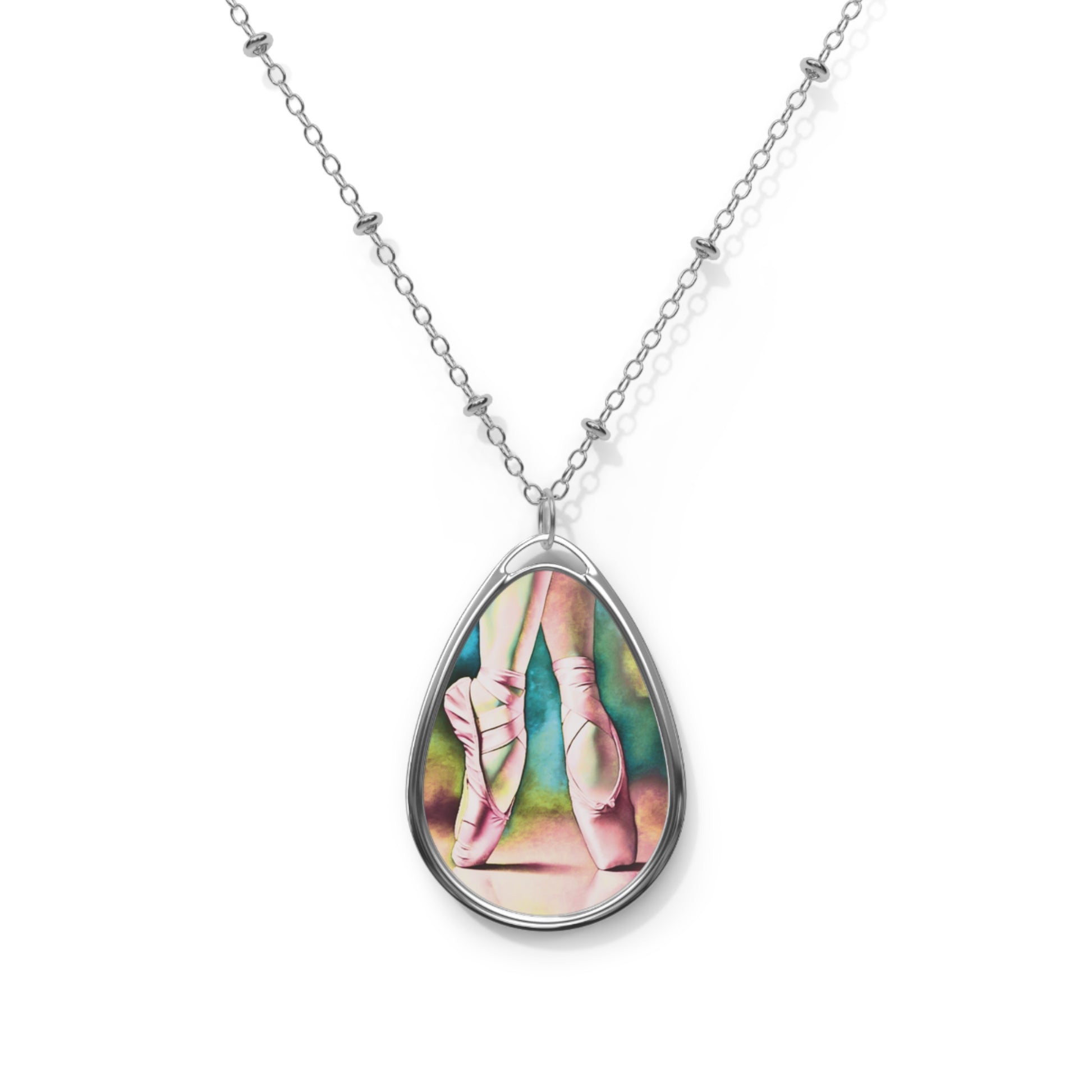 Teardrop-shaped necklace pendant with ballet-themed design on a white background
