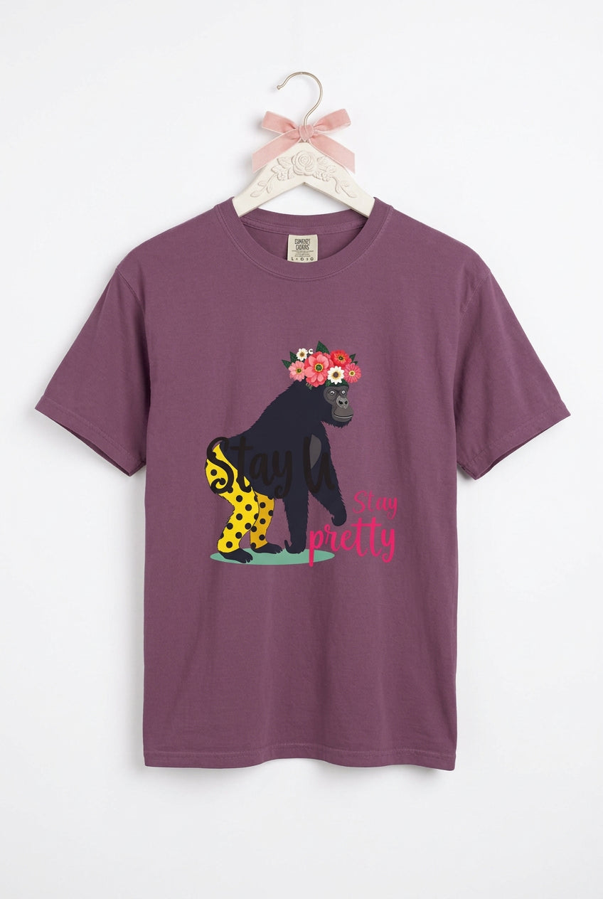 “Girl‑Girl™ gorilla wearing a flower crown and patterned shorts on a Berry unisex tee with the phrase ‘Stay Pretty.’”