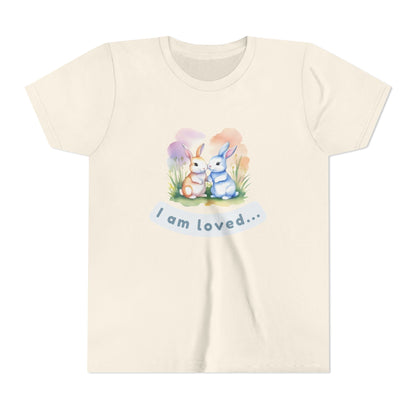 Beige t-shirt with cartoon bunnies and 'I am loved' text on a white background