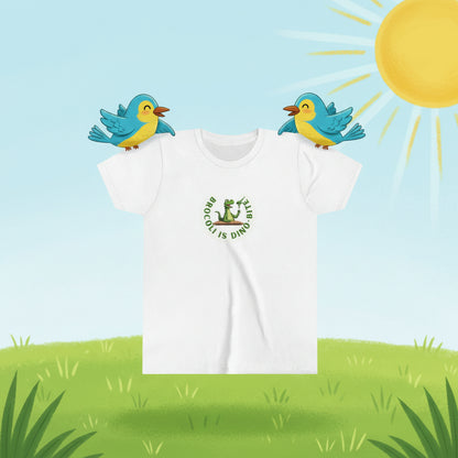 A white short-sleeve crewneck t-shirt featuring a green graphic on the chest of a cartoon dinosaur sitting on a broccoli stem, surrounded by the text 'BROCOLI IS A DINO!'.