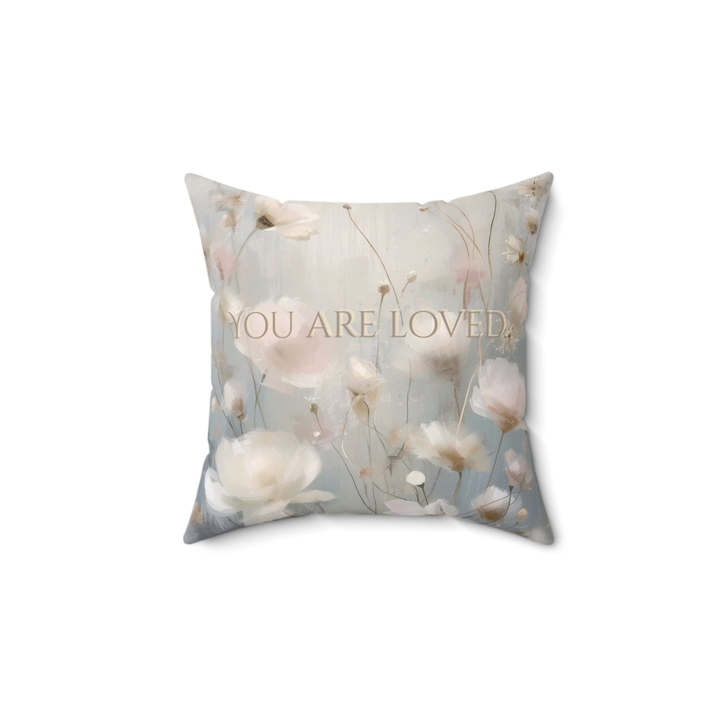 Decorative pillow with floral design and 'YOU ARE LOVED' text on a white background
