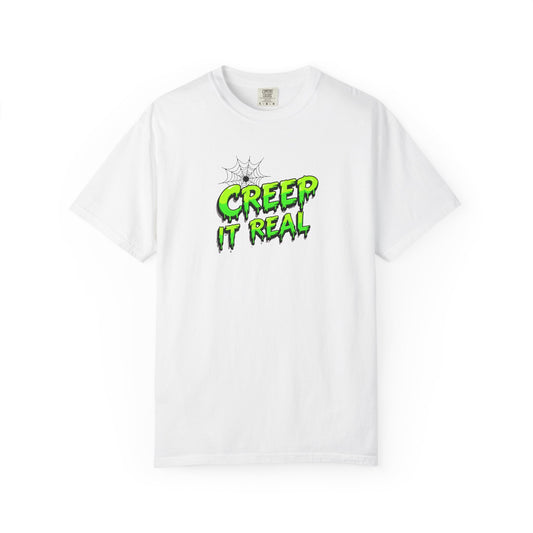 A white short-sleeve crewneck t-shirt featuring a green and black dripping text graphic on the chest that reads 'CREEP IT REAL' with a spiderweb illustration above it, displayed on a clean white background.