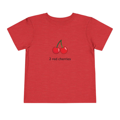 A red short-sleeve crewneck t-shirt featuring a graphic of two red cherries with green stems and the text '2 red cherries' printed below, displayed on a clean white background.