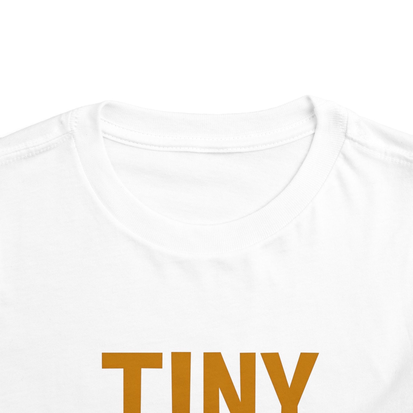 White t-shirt with 'TINY' printed in brown on a white background