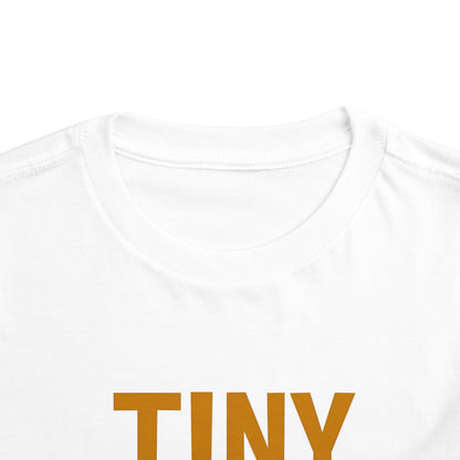 White t-shirt with 'TINY' printed in brown on a white background