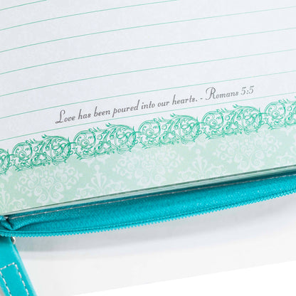 Teal notebook with decorative border and text on a white background