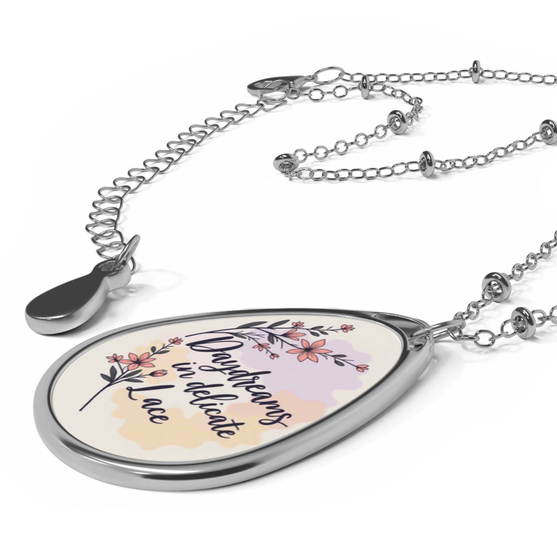 eardrop-shaped pendant with floral design and text on a white background
