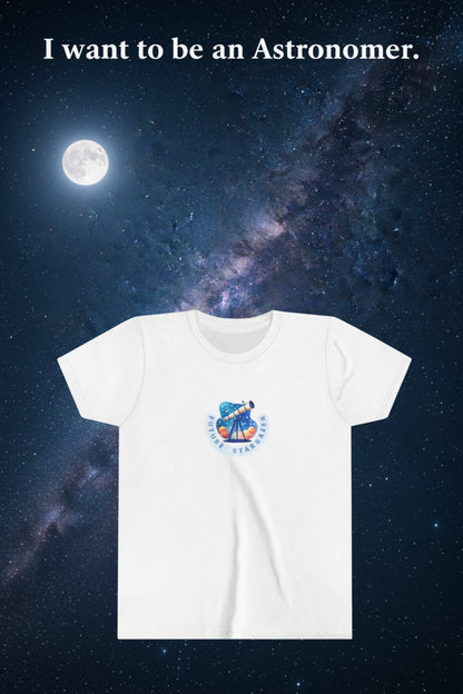 A white short-sleeve crewneck t-shirt featuring a circular graphic on the chest with a blue and orange telescope illustration and the text 'FUTURE STARGAZER'. The title is "I want to be an Astronomer". Malika Bourne legacy design