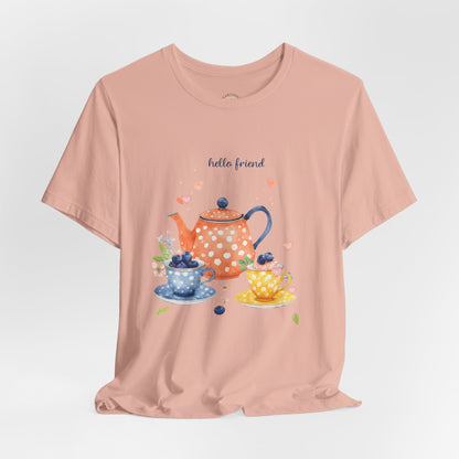 Pink t-shirt with a tea-themed graphic and 'hello friend' text on a light gray background