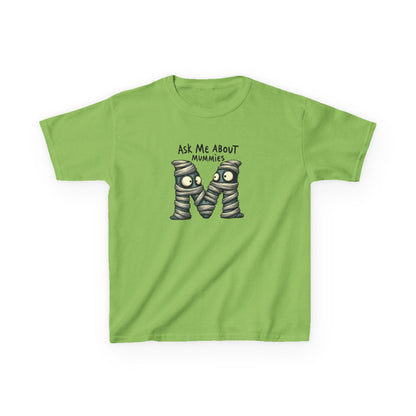 A lime short-sleeve kids' t-shirt with a graphic of two cartoon mummies and the text 'ASK ME ABOUT MUMMIES' printed on the chest, displayed on a clean white background.