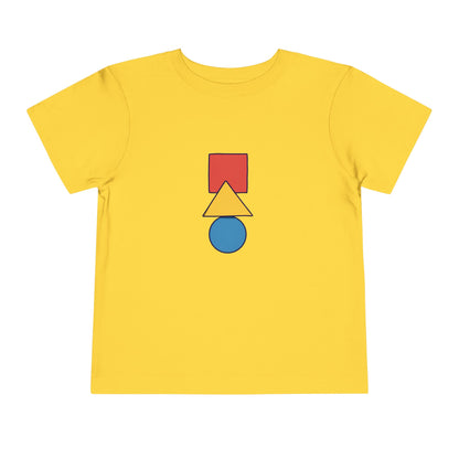 A yellow short-sleeve t-shirt with a central graphic of stacked geometric shapes: a red square, a yellow triangle, and a blue circle, shown on a plain white background.