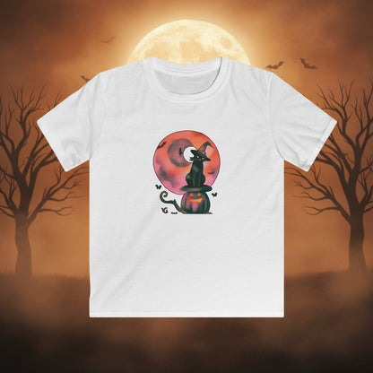 A white short-sleeve crewneck t-shirt featuring a Halloween graphic of a black witch cat sitting on a jack-o'-lantern pumpkin in front of a pink and orange full moon.