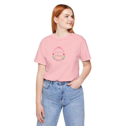 Person wearing a pink t-shirt with text and jeans on a white background