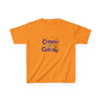 An orange short-sleeve kids' t-shirt with a 'Creepin' Cute' Halloween graphic on the chest, featuring purple text, a spider, and small stars, displayed on a clean white background.Tennessee orange