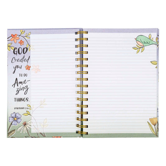 Open notebook with motivational quote and floral design on a white background