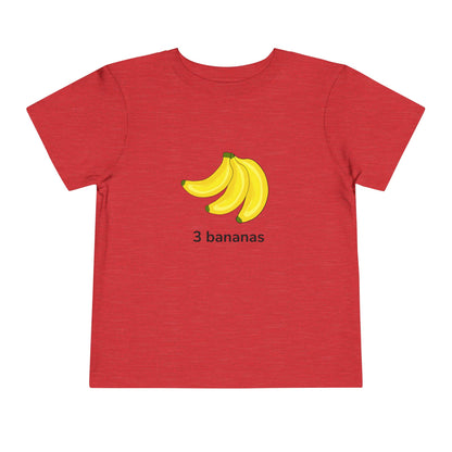 A red short-sleeve t-shirt with a graphic of three yellow bananas and the text '3 bananas' printed on the chest, displayed on a solid white background.