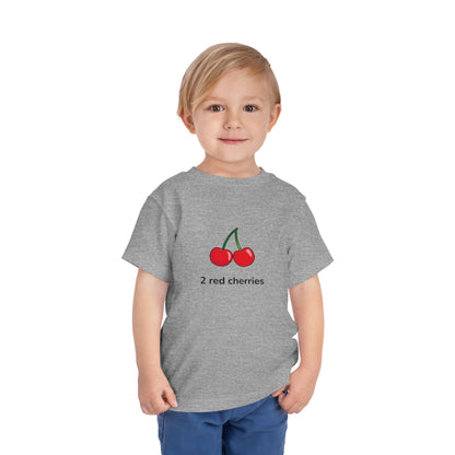 A young child wearing a heather gray graphic T-shirt with the text 'SMALL BUT MIGHTY.' in black and red, paired with blue pants, standing against a plain white background.