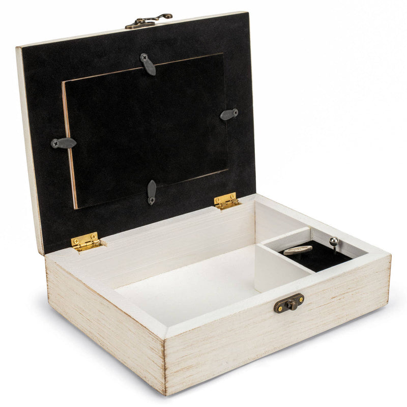 Wooden jewelry box with black interior with windup music key on a white background