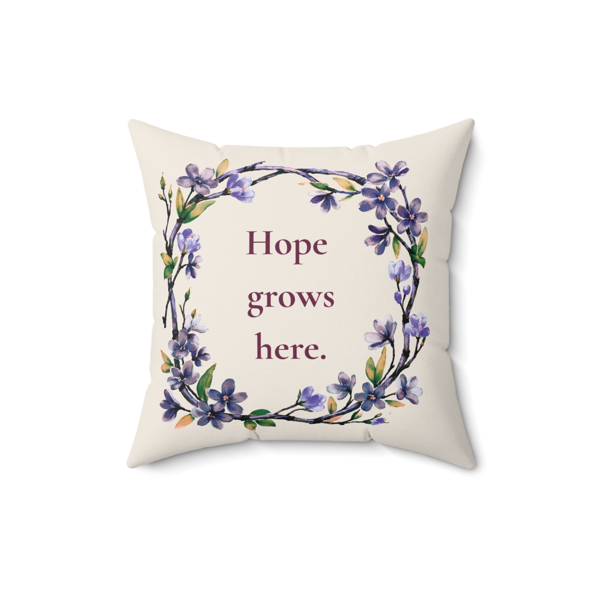 Decorative pillow with floral design and 'Hope grows here' text on a white background