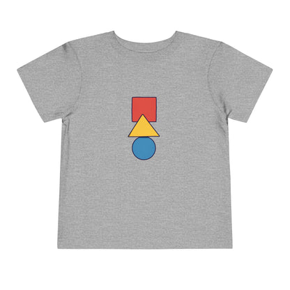 A heather gray short-sleeve t-shirt with a central graphic of three stacked geometric shapes: a red square, a yellow triangle, and a blue circle.