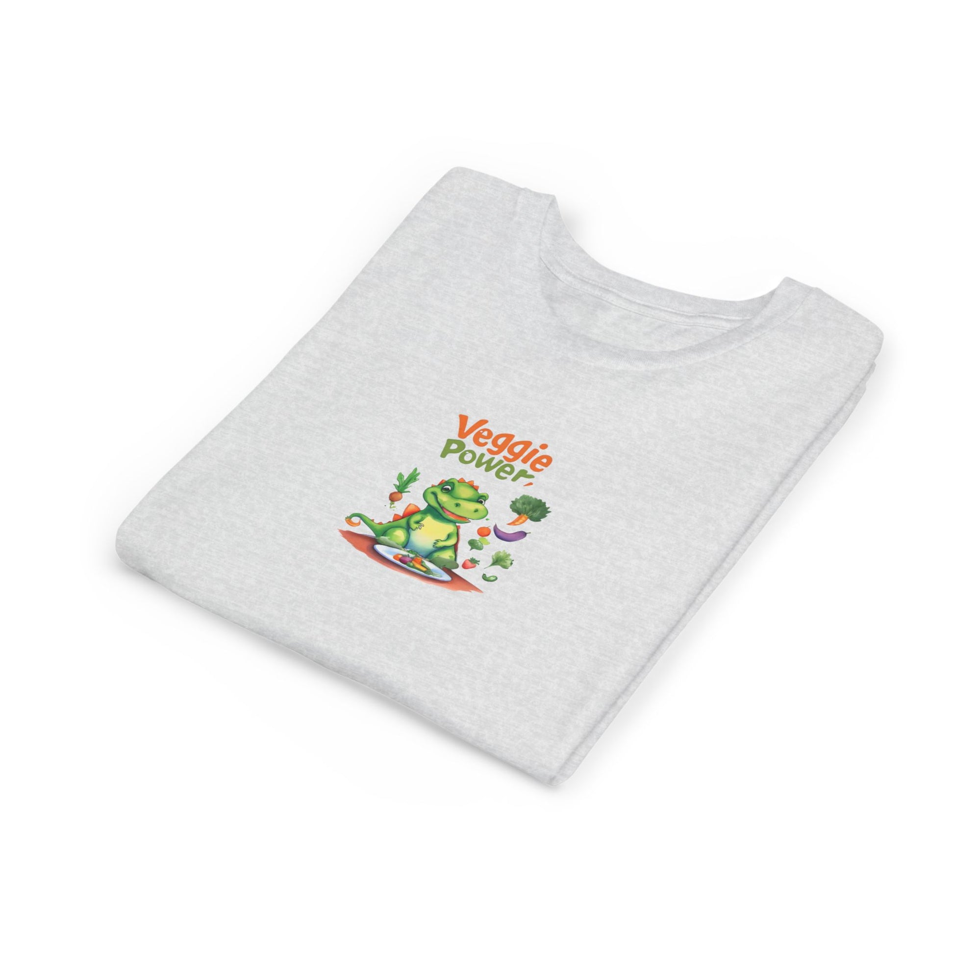 A light gray heathered t-shirt folded neatly, featuring a colorful graphic of a cartoon frog wearing sunglasses and a red surfboard with the text 'Veggie Power' in orange and green.