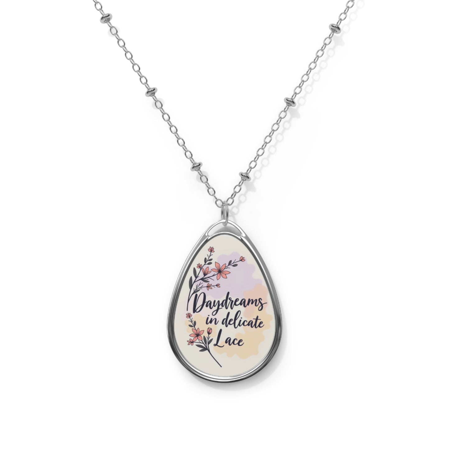 Teardrop-shaped pendant with floral design and text on a white background
