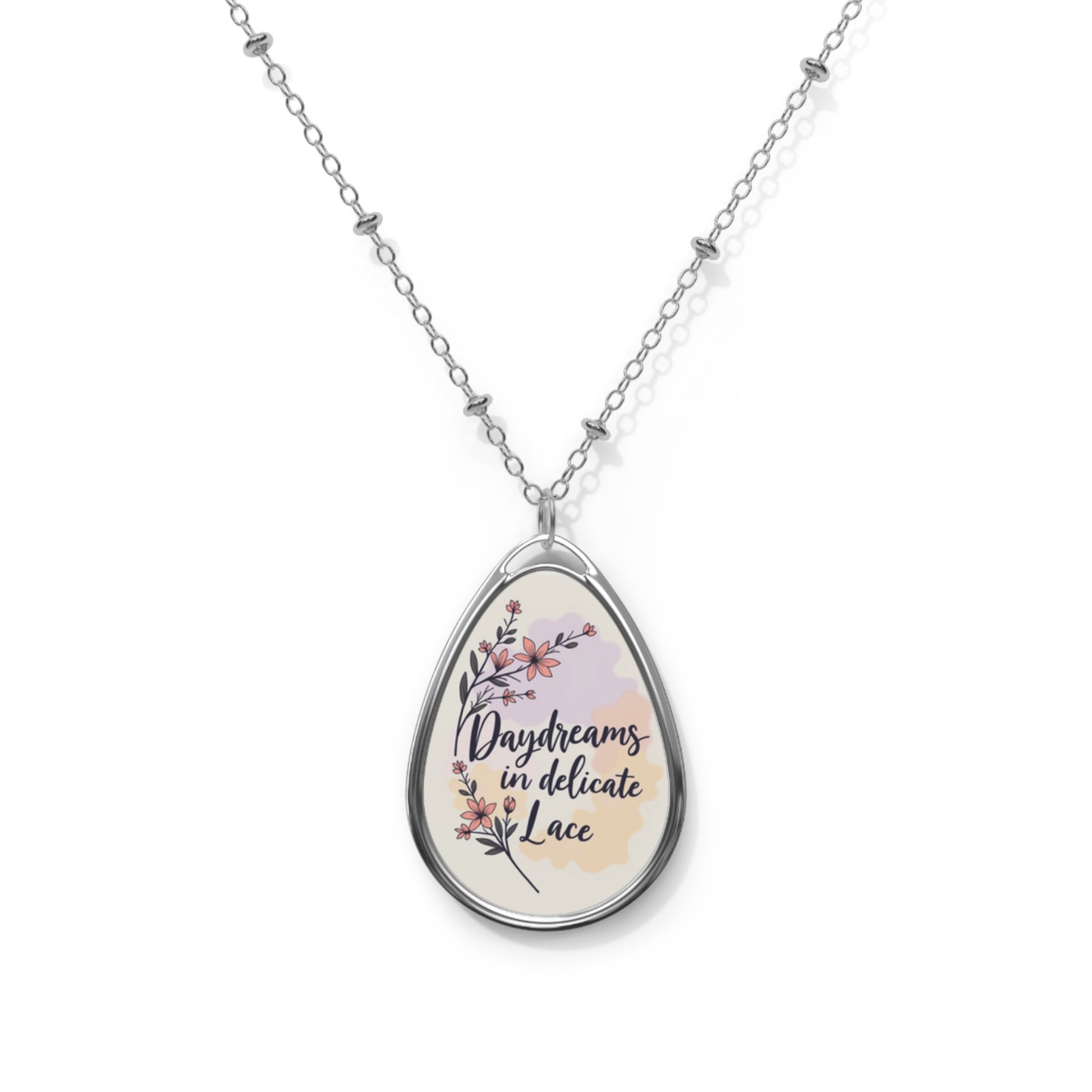 Teardrop-shaped pendant with floral design and text on a white background