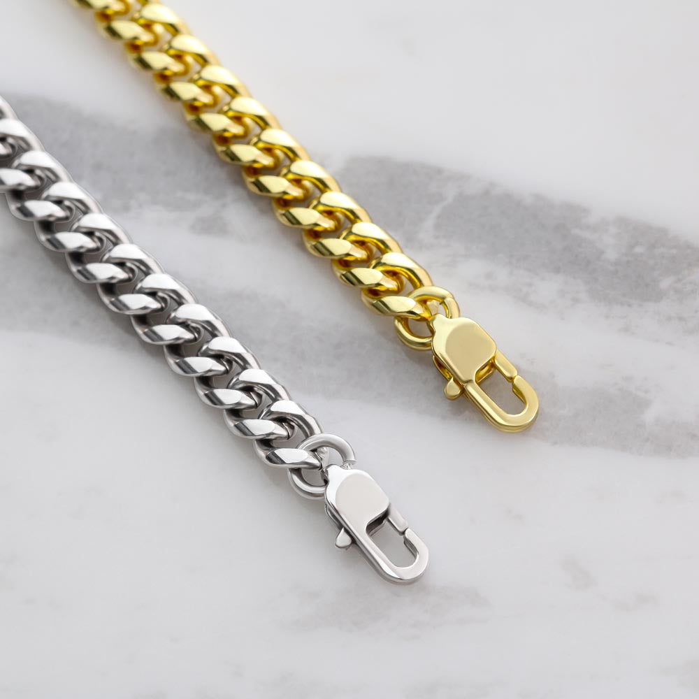 Stainless stee and 18K gold Cuban link chain laid out to show parrot latches on end of chain.