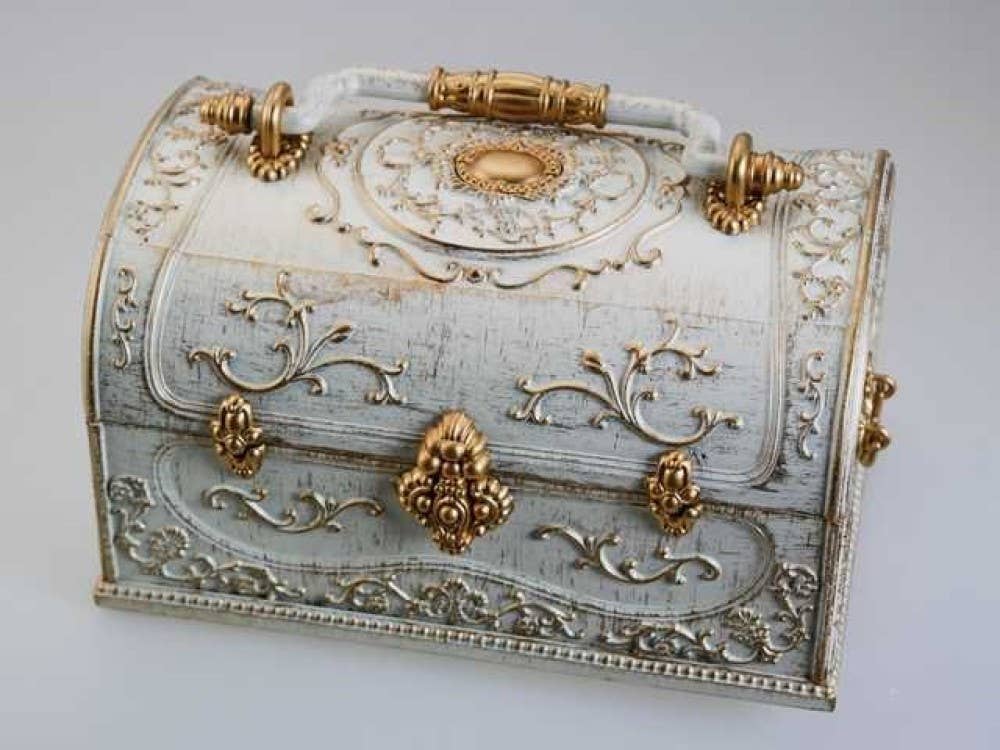 Decorative chest with intricate gold designs on a light gray background