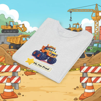 A folded white kid's T-shirt with a cartoon graphic of a yellow construction vehicle and the text 'Hi, I'm Fred' on the front, set against a cartoon construction site background.