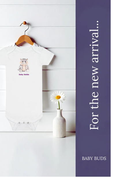 A white baby bodysuit with a small cartoon hippo graphic and the text 'Baby Buds' hangs on a wooden hanger against a white paneled wall, next to a small white vase with a daisy. A dark purple vertical banner on the right reads 'For the new arrival.